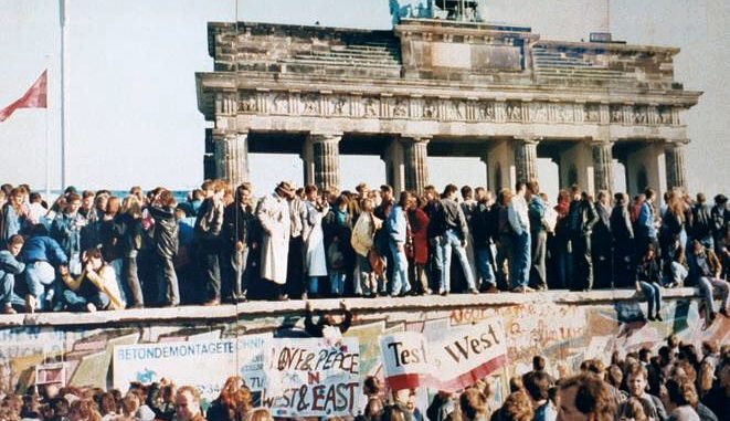 The Fall of the Berlin Wall, 1989. The photo shows a part of a public photo documentation wall at the Brandenburg Gate, Berlin. The photo documentation is permanently placed in the public. Photo by Lear 21 at English Wikipedia, CC BY-SA 3.0, https://commons.wikimedia.org/w/index.php?curid=3692038