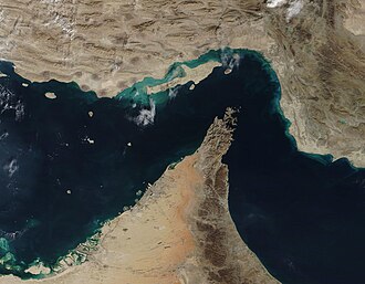 The narrow Strait of Hormuz lies between the Persian Gulf and the Gulf of Oman, separating Iran (north) from the Arabian Peninsula (south). Only about 21 miles (34 km) wide at the narrowest point and roughly 96 miles (155 km) long, about thirty percent of the world’s seaborne oil and nearly one-quarter of the liquified natural gas (LNG) supply passes through this strait — all on shipping lanes that measure only two-mile wide. It has been estimated that 21 million barrels of oil, with a value of 1.2 billion US dollars (USD), pass through the strait every day. Photo by MODIS Land Rapid Response Team, NASA GSFC - This image or video was catalogued by Goddard Space Flight Center of the United States National Aeronautics and Space Administration (NASA) under Photo ID: 2020-12-04., Public Domain, https://commons.wikimedia.org/w/index.php?curid=144938834