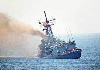 A port quarter view of the guided missile frigate USS STARK (FFG-31) listing to port after being struck by an Iraqi-launched Exocet missile. Photo by US Navy - commons file, Public Domain, https://commons.wikimedia.org/w/index.php?curid=65637523