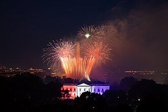 Fireworks appear above the White House North Portico lit in red-white and blue lights Saturday evening, July 4, 2020, during the Salute to America 2020, Fourth of July celebration. Photo by The White House from Washington, DC - Salute to America 2020, Public Domain, https://commons.wikimedia.org/w/index.php?curid=91969976