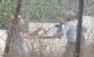 Moment that a rifle was pulled from the arms of a civilian security officer while confronting an Arab mob attacking Jewish hikers in Shomron.  Screengrab via Social Media
